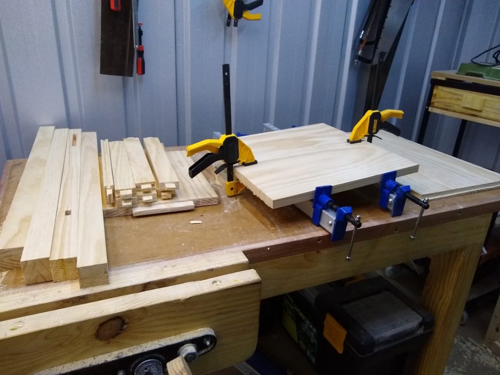 Laminating boards to make the base. All the pieces ready to assemble on the left