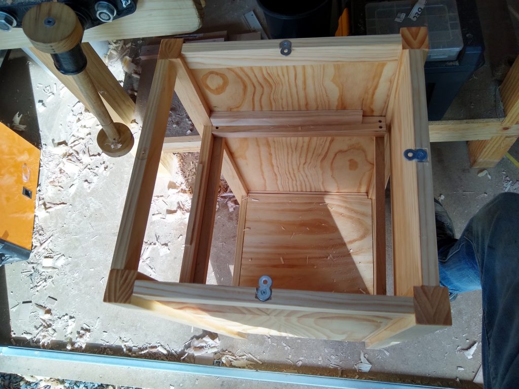 The top is attached with figure 8 clips recessed into the top of the frame so the top is flush with the top of the frame