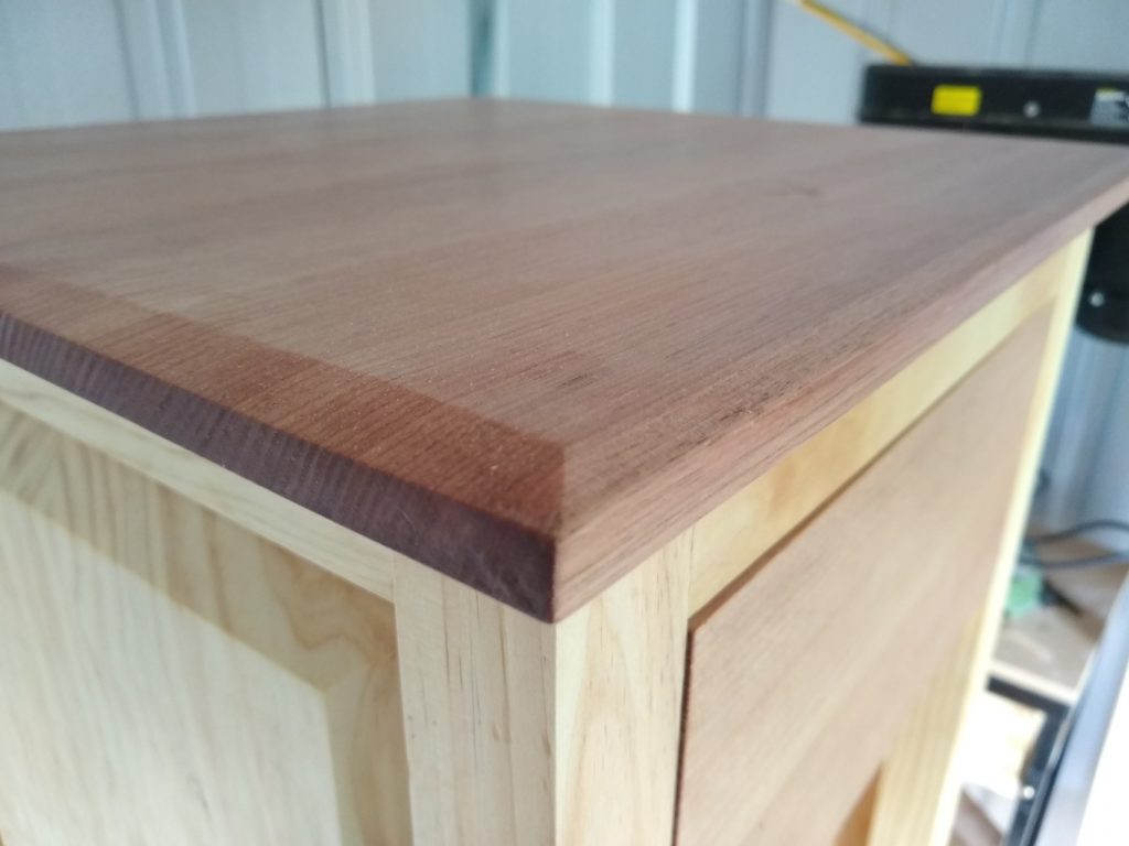 The top is made of 5 90mm x 19mm boards laminated together. Once glued, the edges were bevelled to match the styling on the panels